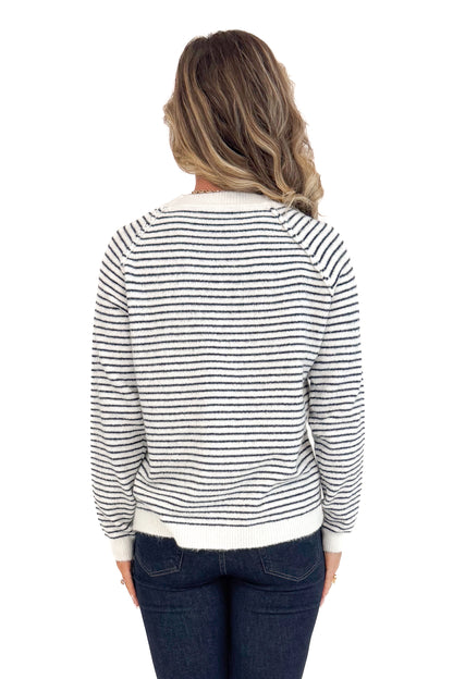 Back view of woman wearing Cream &amp; Black Striped Long Sleeve Top and blue jeans. 