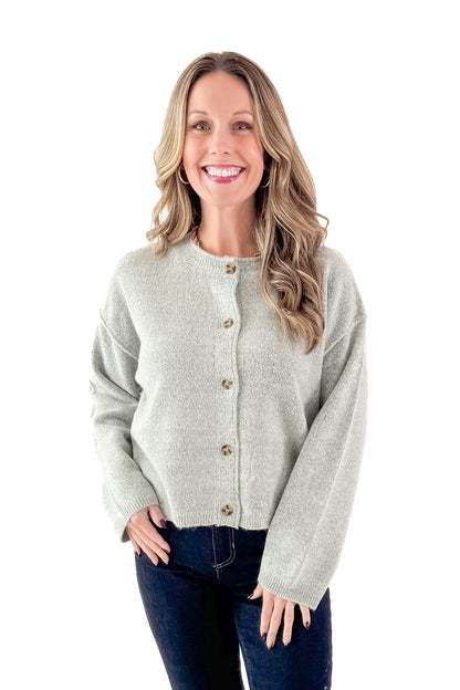 Front view of woman wearing Heather Grey Button Up Cardigan with jeans against white studio background.