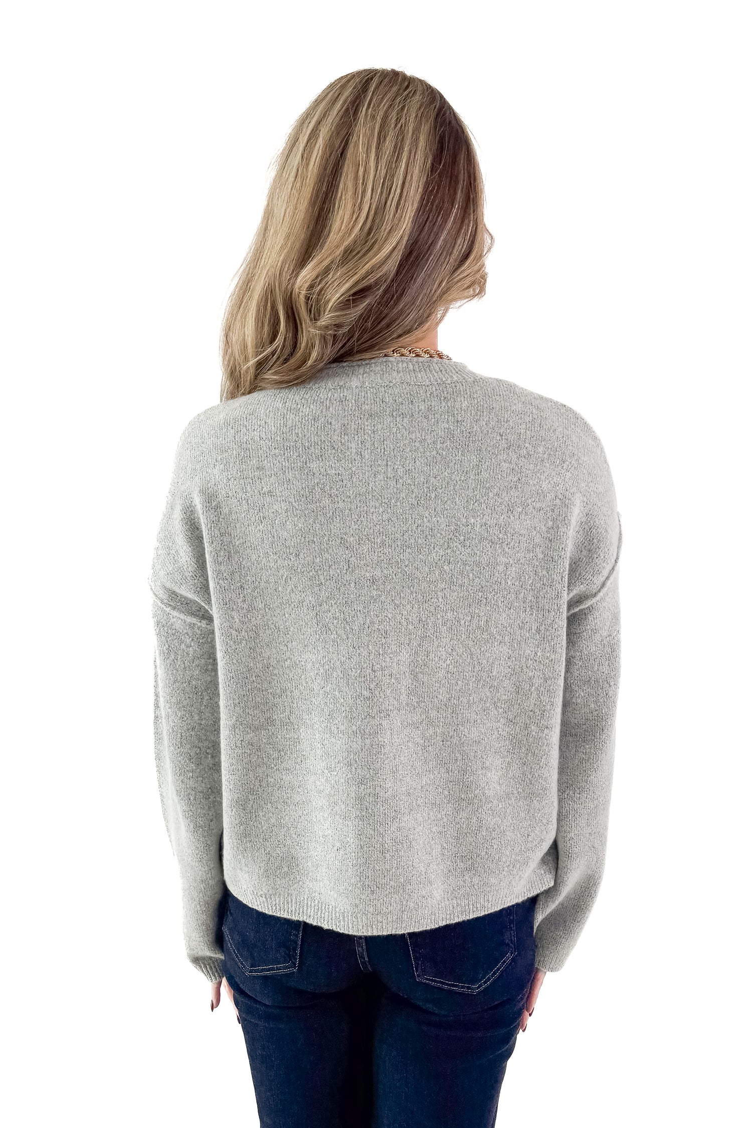 Back view of woman wearing Heather Grey Button Up Cardigan with jeans against white studio background.