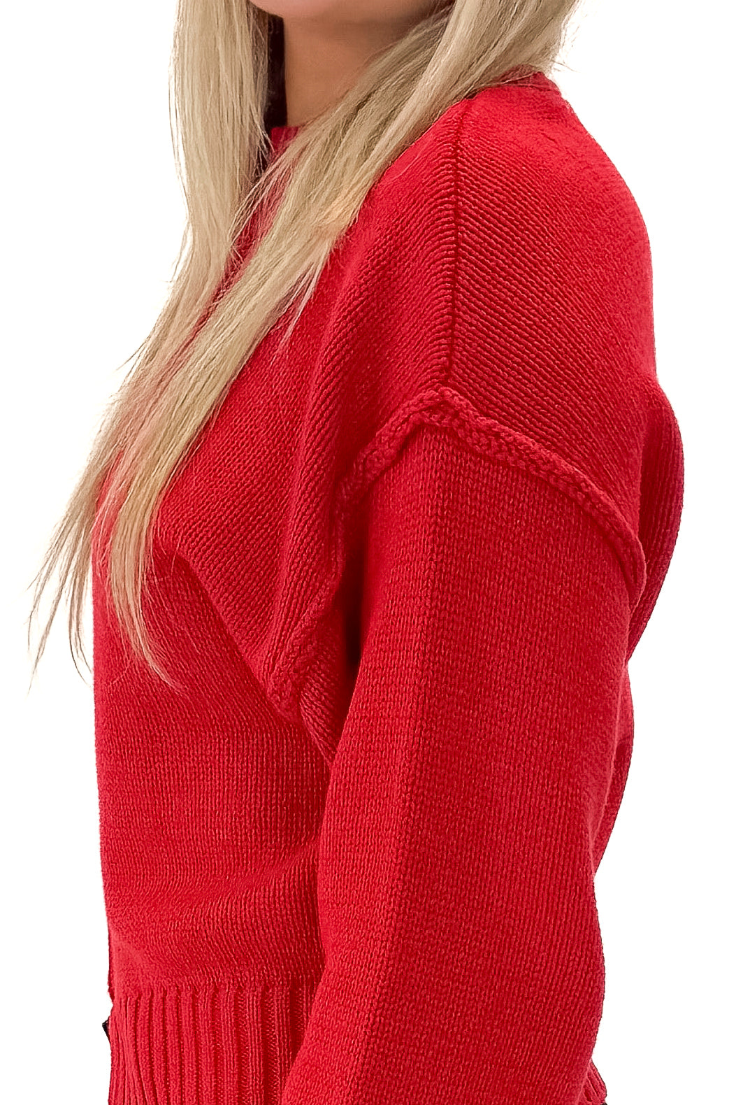 Side detail view of woman wearing Red Seam Split Detail Sweater with jeans against white studio background.