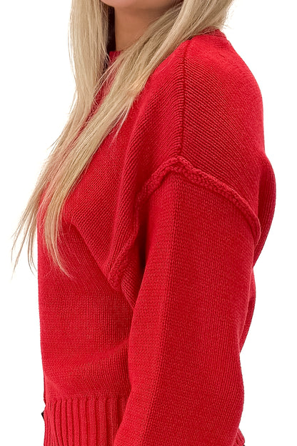 Side detail view of woman wearing Red Seam Split Detail Sweater with jeans against white studio background.
