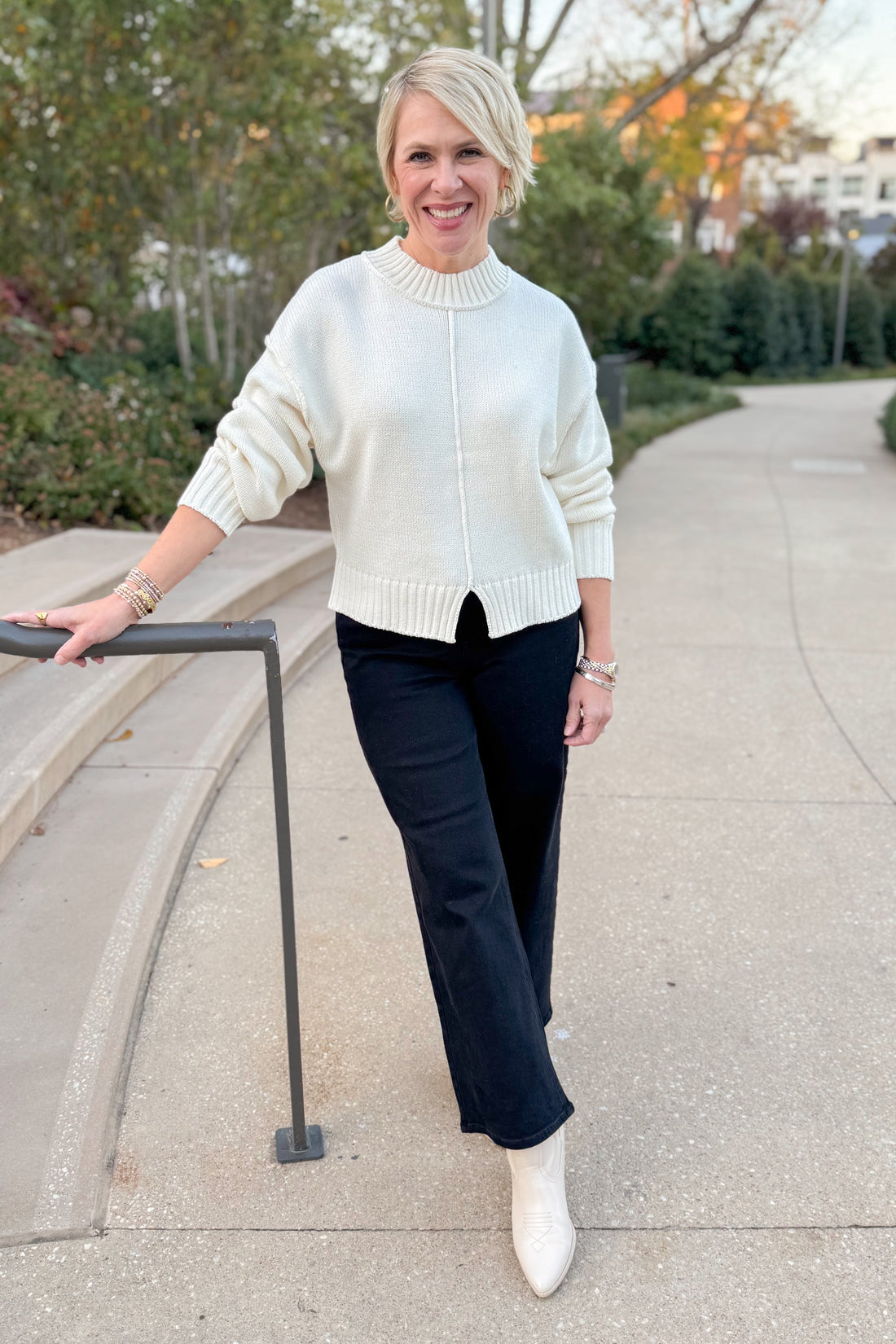 Front view of woman wearing Cream Seam Split Detail Sweater with jeans outside.