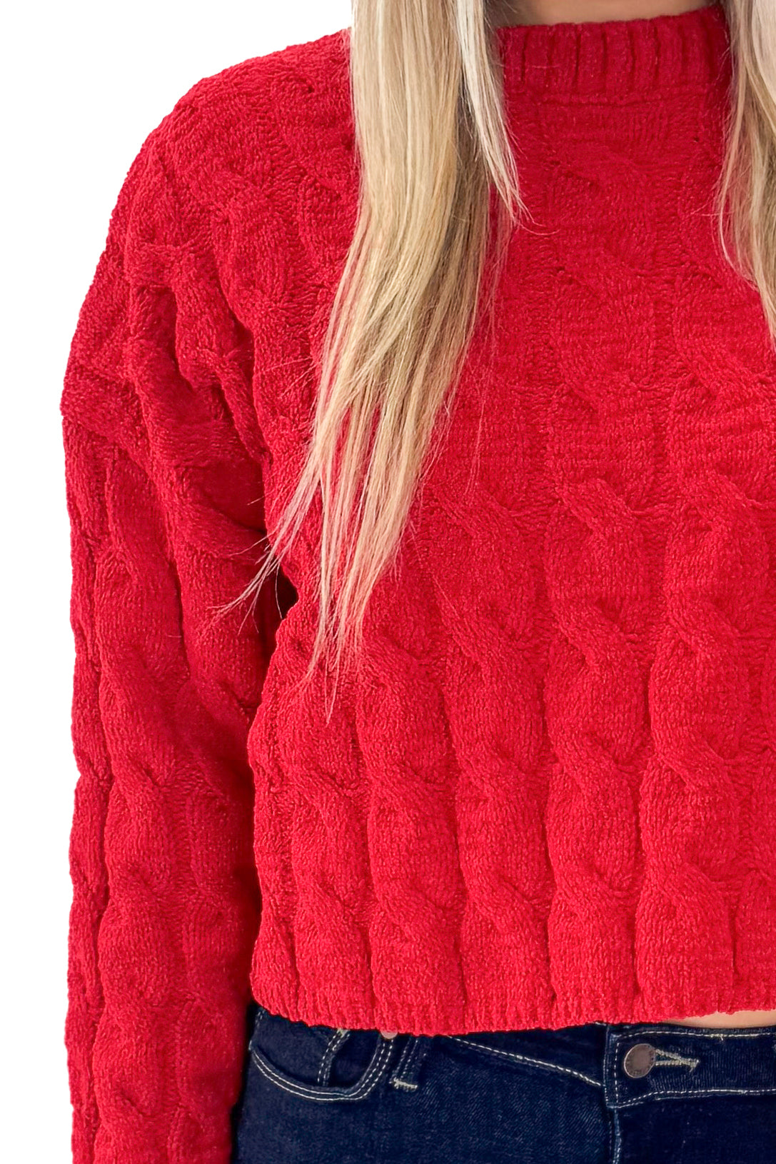Front detail view of woman wearing Red Textured Cable Knit Sweater with skirt against white studio background.