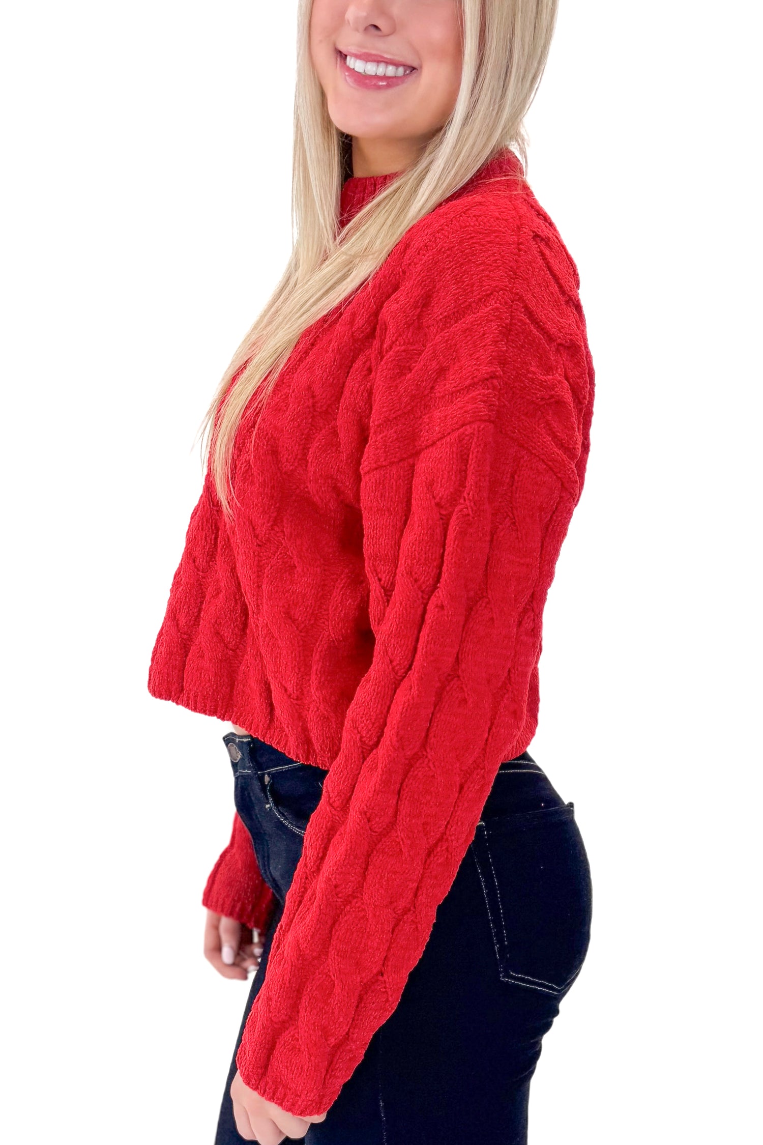 SIde view of woman wearing Red Textured Cable Knit Sweater with skirt against white studio background.