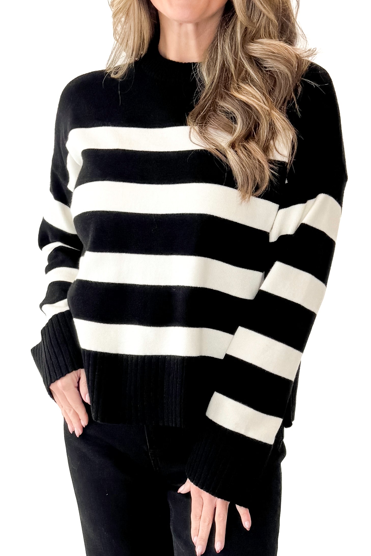 Front view of woman wearing Black and Cream Striped Crewneck Sweater with jeans against white studio background.