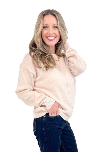 Side view of woman wearing Light Taupe Center Seam Sweater and jeans. 