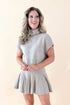 Front view of woman wearing Taupe Pleated Sweater Skirt with matching sweater against tan studio background.