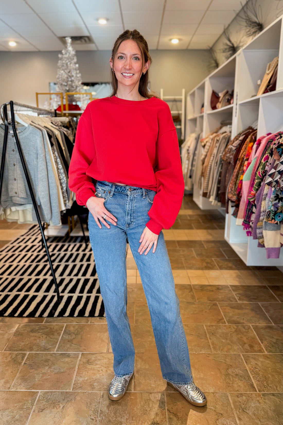 Front view of woman wearing Red Elastic Hem Sweatshirt with jeans at a boutique.