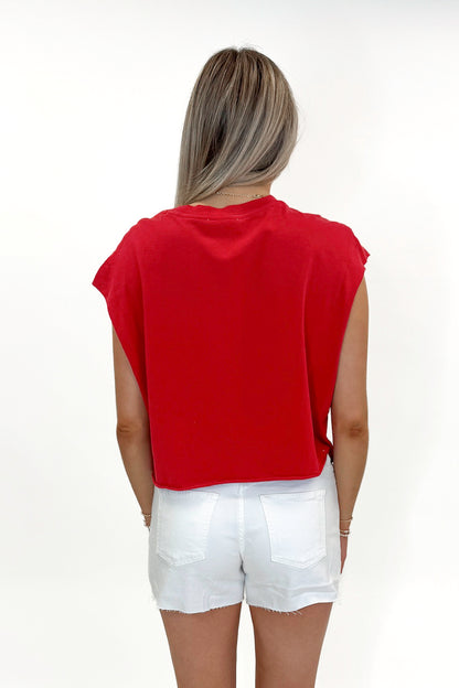 Back view of woman wearing Red Boxy Tee with jean shorts against white studio background.