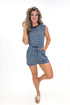 Front view of woman wearing Navy Striped Drawstring Romper with sandals against white studio background.