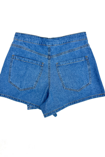 Flat lay of Medium Wash Denim Wrap Skort against white studio background.