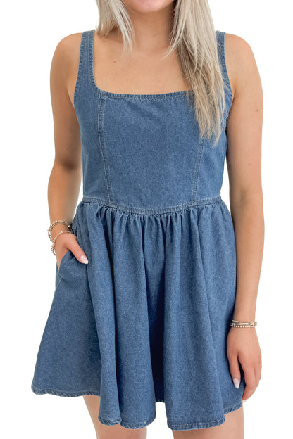 Front detail view of woman wearing Denim Tank Dress against white studio background.