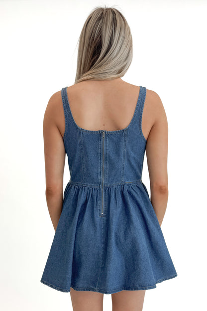 Back view of woman wearing Denim Tank Dress against white studio background.