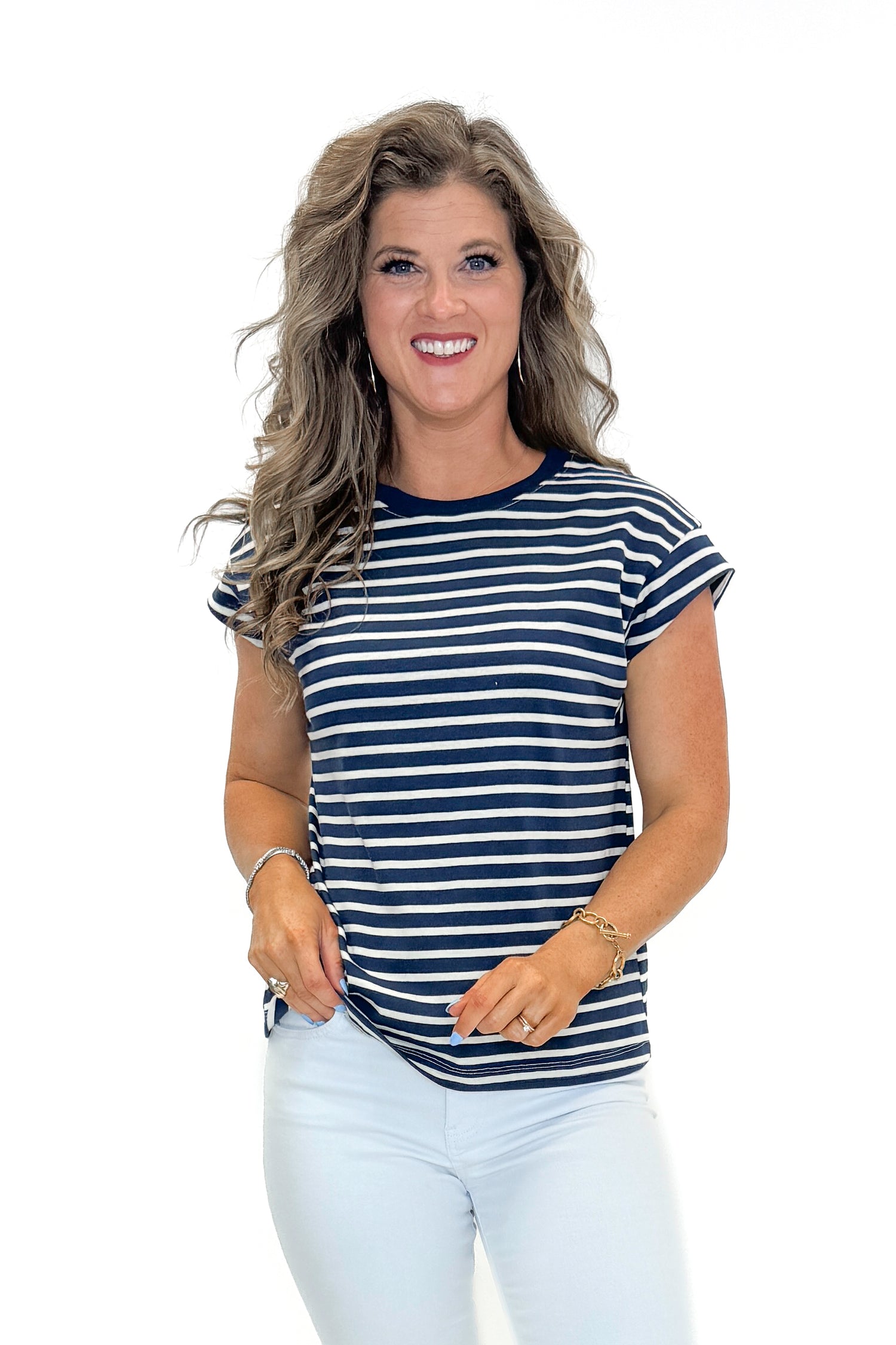 Front view of woman wearing Navy &amp; Cream Stripe Cap Sleeve Tee with jeans against white studio background.