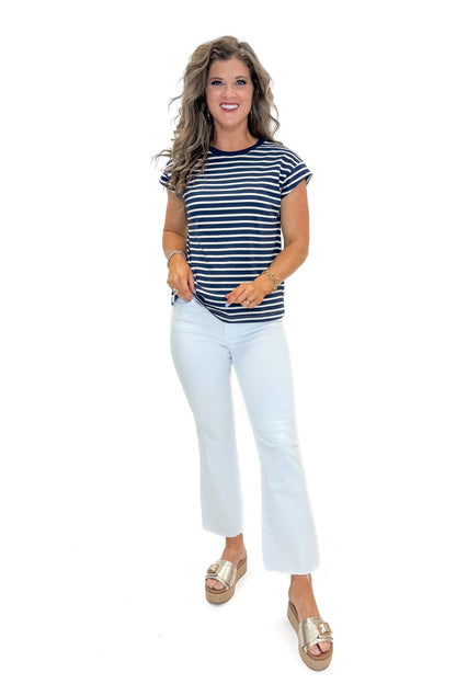 Front view of woman wearing Navy &amp; Cream Stripe Cap Sleeve Tee with jeans against white studio background.