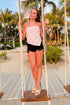 Front view of woman wearing Red Polka Dot Strapless Top with jean shorts outside at the beach.