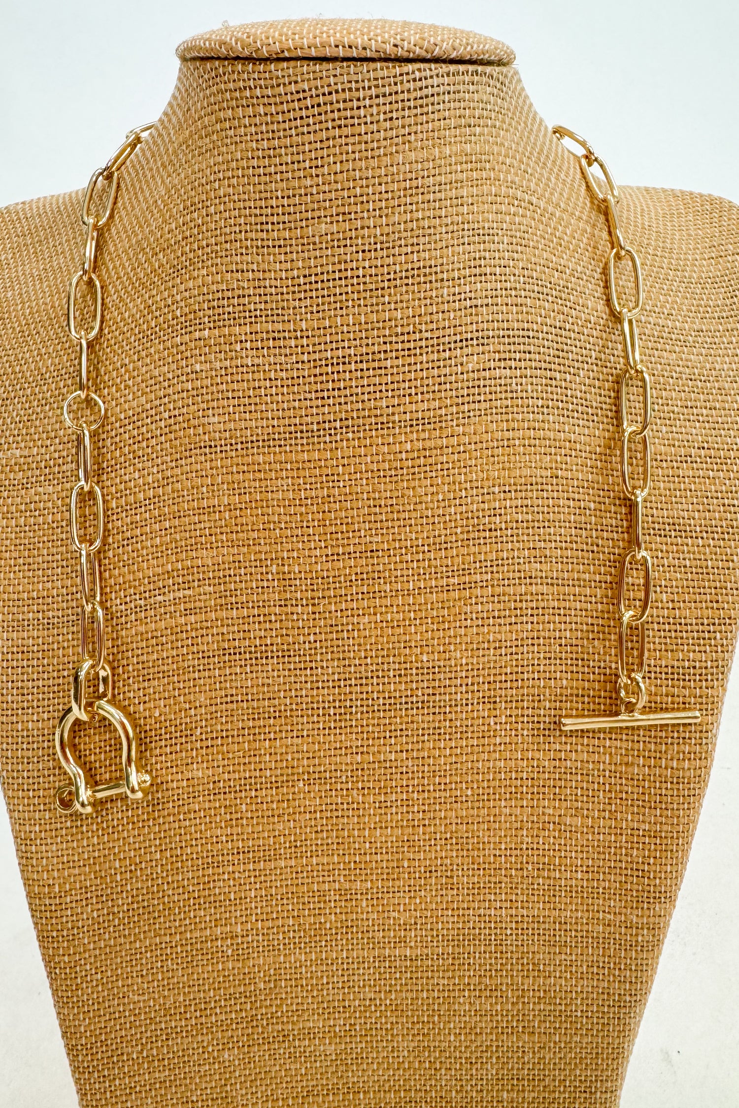 Gold chain necklace on a brown mannequin bust
