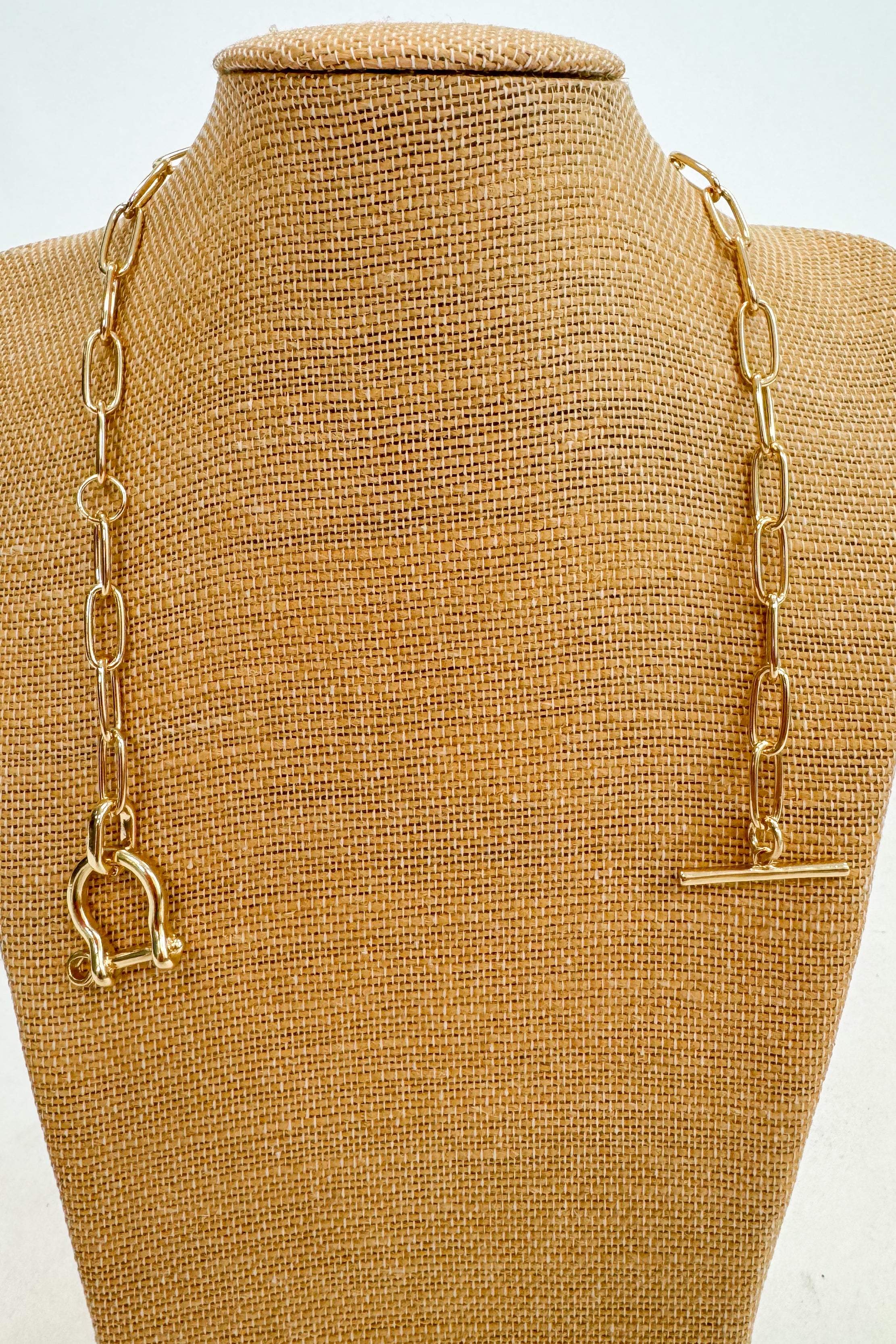 Gold chain necklace on a brown mannequin bust