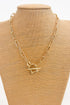 Gold chain necklace with a horsebit pendant on a beige mannequin bust.