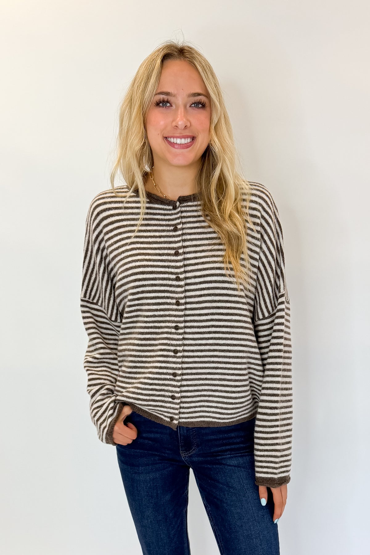 Front view of woman wearing Swagger Boutique’s Dark Brown &amp; Cream Striped Button Up Cardigan with jeans against white studio background.
