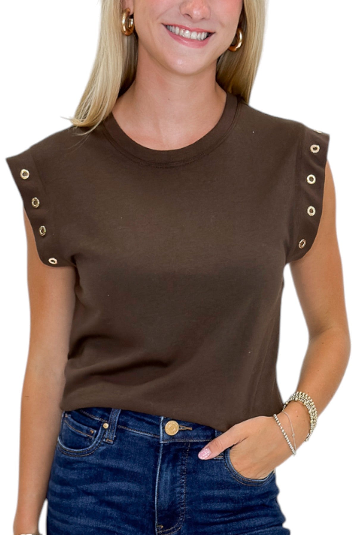 Front detail view of woman wearing Swagger Boutique’s Dark Chocolate Camino Grommet Top by Z Supply with jeans against white studio background.