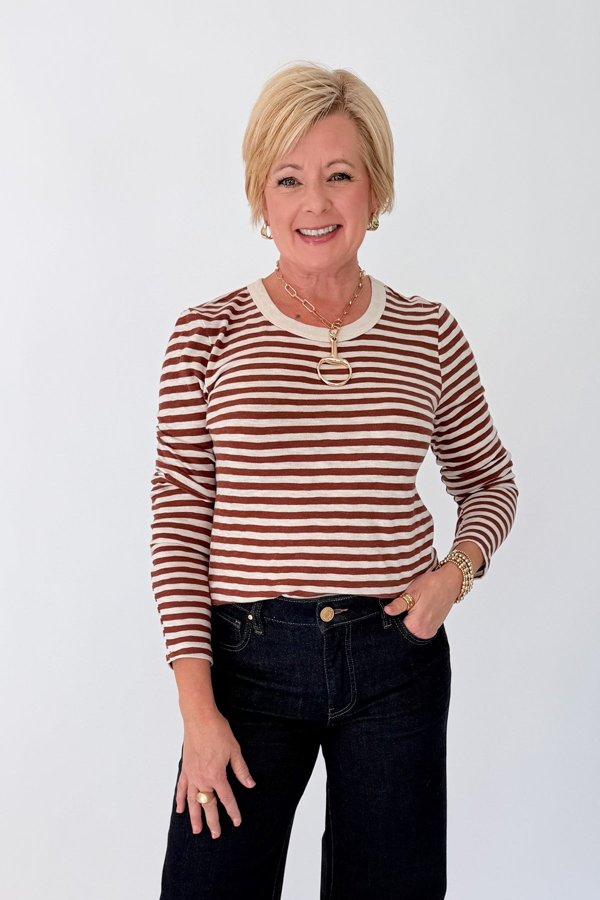 Front view of woman wearing Swagger Boutique’s Dark Rosewood Junie Long Sleeve Stripe Slub Tee by Z Supply with jeans against white studio background.