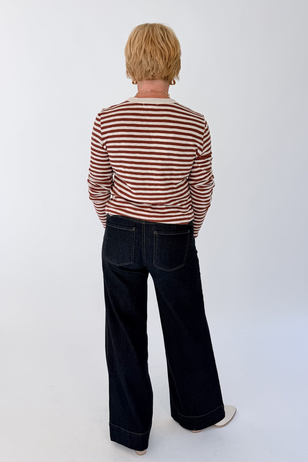 Back view of woman wearing Swagger Boutique’s Dark Rosewood Junie Long Sleeve Stripe Slub Tee by Z Supply with jeans against white studio background.