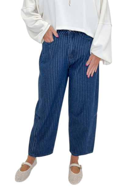 Front detail view of woman wearing Swagger Boutique’s Dark Wash Pinstriped Barrel Jeans with top against white studio background.