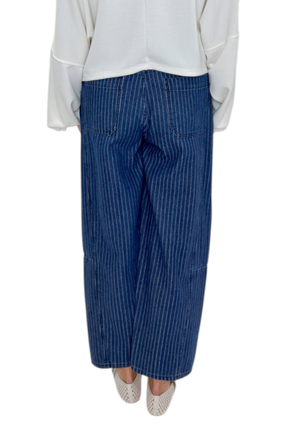 Back view of woman wearing Swagger Boutique’s Dark Wash Pinstriped Barrel Jeans with top against white studio background.