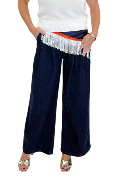 Front detail view of woman wearing Swagger Boutique’s Dark Wash Pleated Trouser Jeans by Risen with sweater &amp; scarf against white studio background.