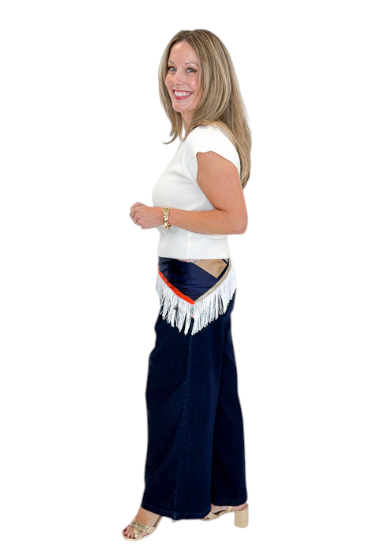 Side view of woman wearing Swagger Boutique’s Dark Wash Pleated Trouser Jeans by Risen with sweater &amp; scarf against white studio background.