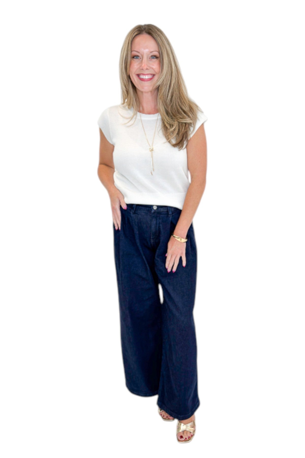 Front view of woman wearing Swagger Boutique’s Dark Wash Pleated Trouser Jeans by Risen with sweater against white studio background.