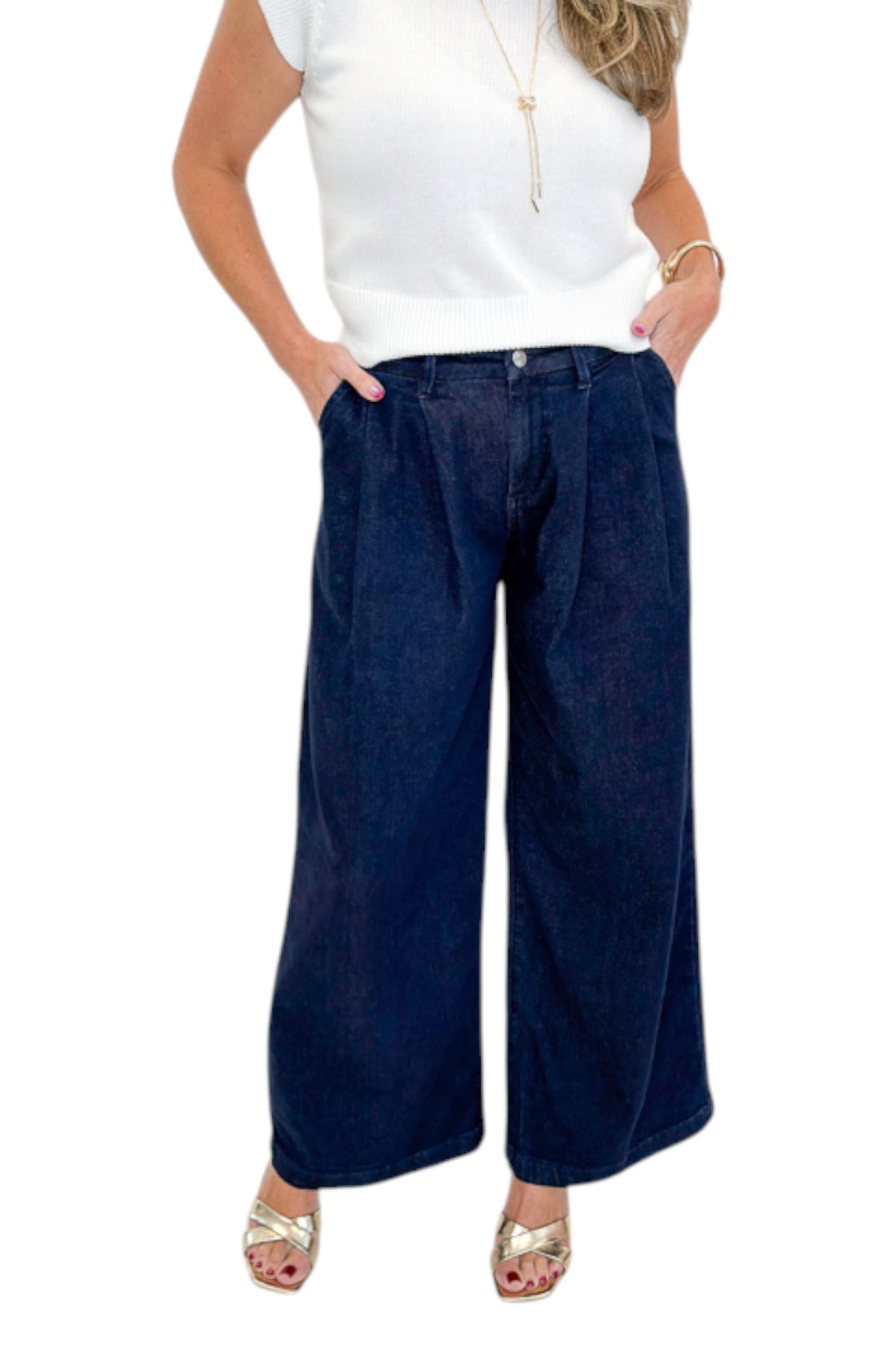 Front detail view of woman wearing Swagger Boutique’s Dark Wash Pleated Trouser Jeans by Risen with sweater against white studio background.