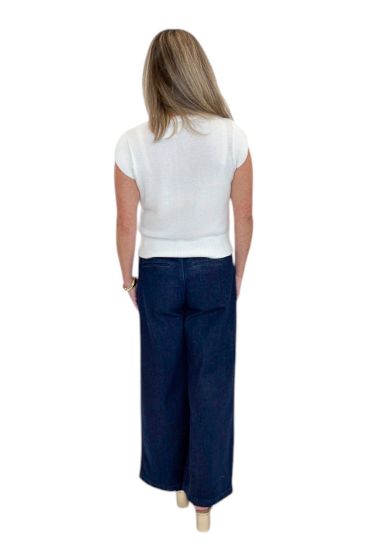 Back view of woman wearing Swagger Boutique’s Dark Wash Pleated Trouser Jeans by Risen with sweater against white studio background.