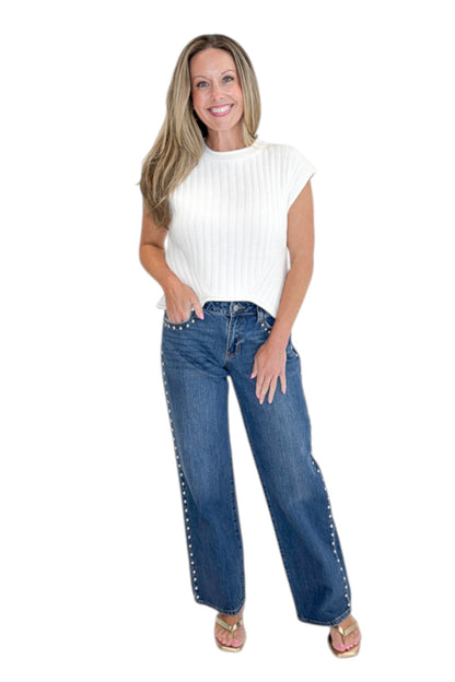 Front view of woman wearing Swagger Boutique’s sweater with Dark Wash Stud Jeans by Just Black Denim against white studio background.