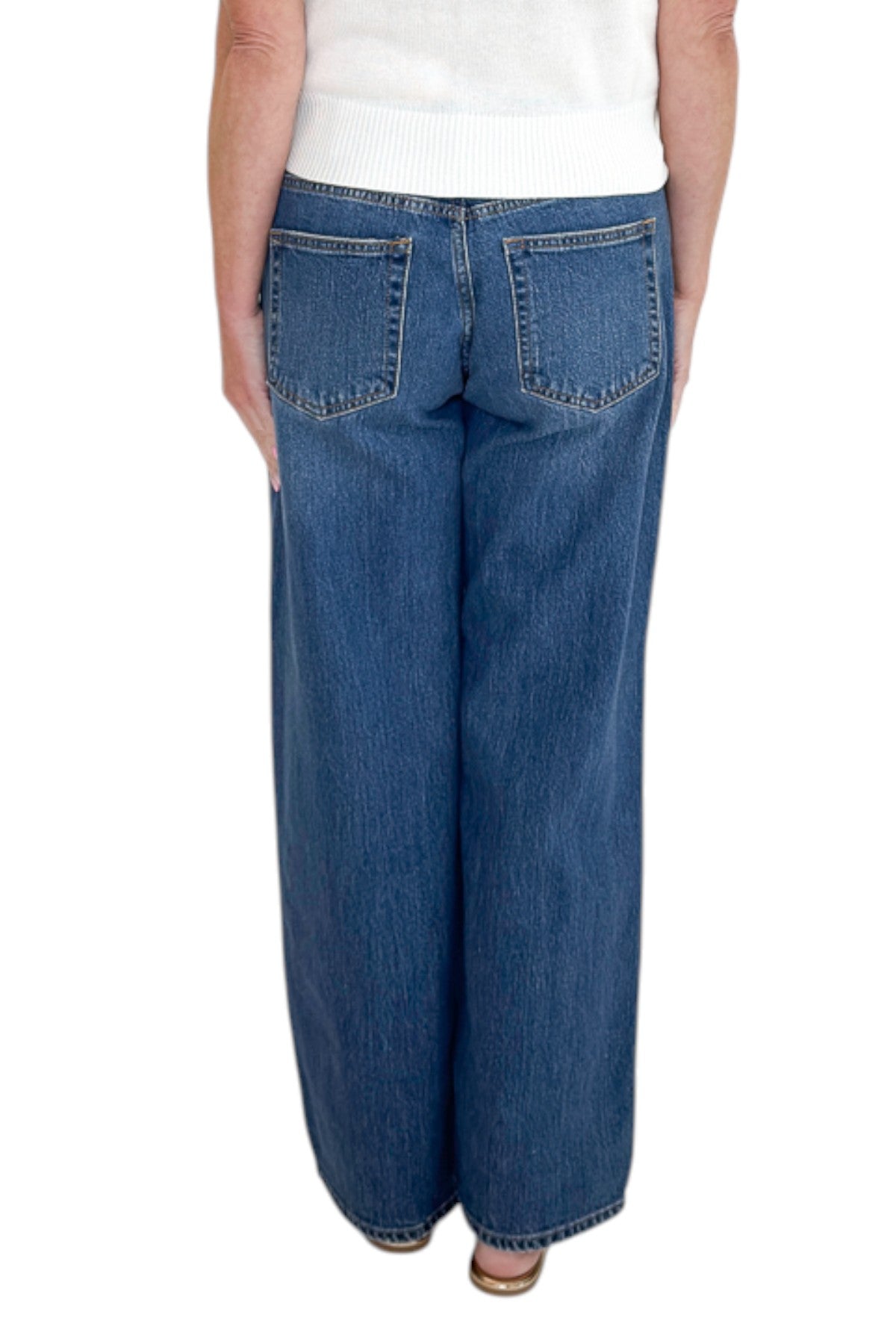Back view of woman wearing Swagger Boutique’s sweater with Dark Wash Stud Jeans by Just Black Denim against white studio background.