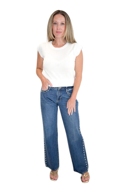 Front view of woman wearing Swagger Boutique’s sweater with Dark Wash Stud Jeans by Just Black Denim against white studio background.