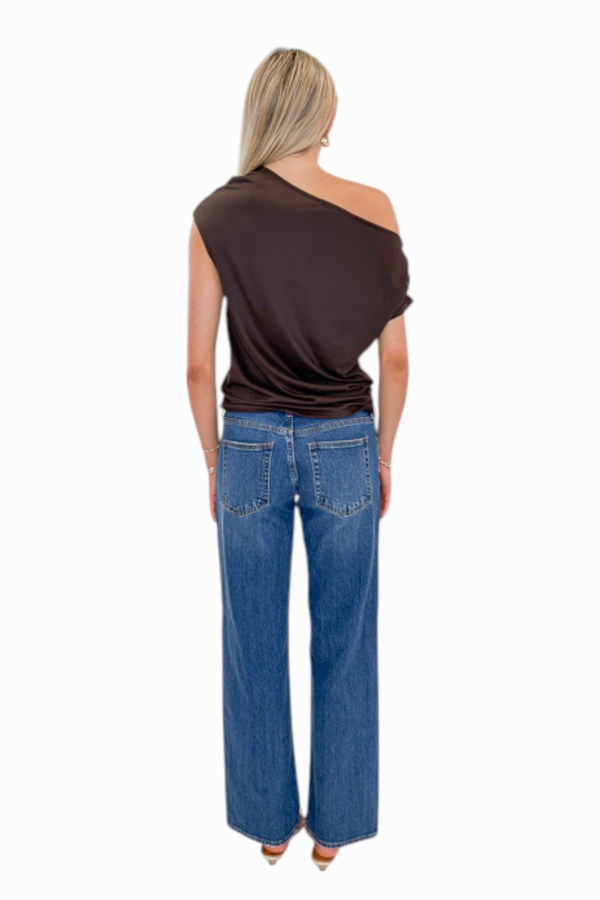 Back view of woman wearing Swagger Boutique’s Dark Wash Stud Jeans by Just Black Denim against white studio background.