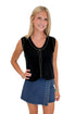 Front view of woman wearing Swagger Boutique’s Black Studded Sweater Vest with Dark Wash Studded Denim Skort against white studio background.
