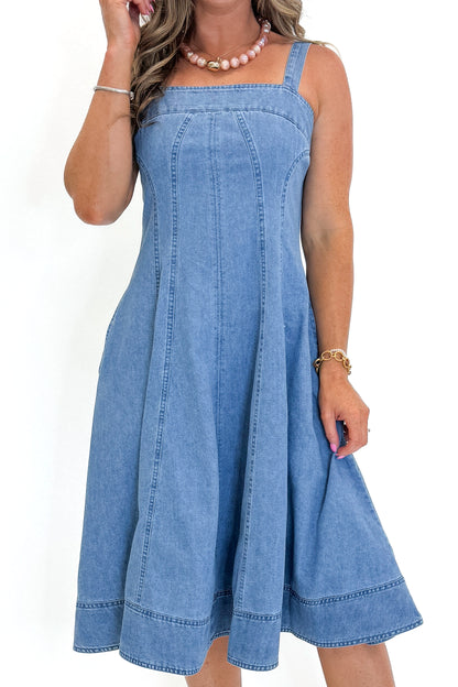 Front detail view of woman wearing Swagger Boutique’s Denim Fit &amp; Flare Midi Dress with jeans sandals white studio background.