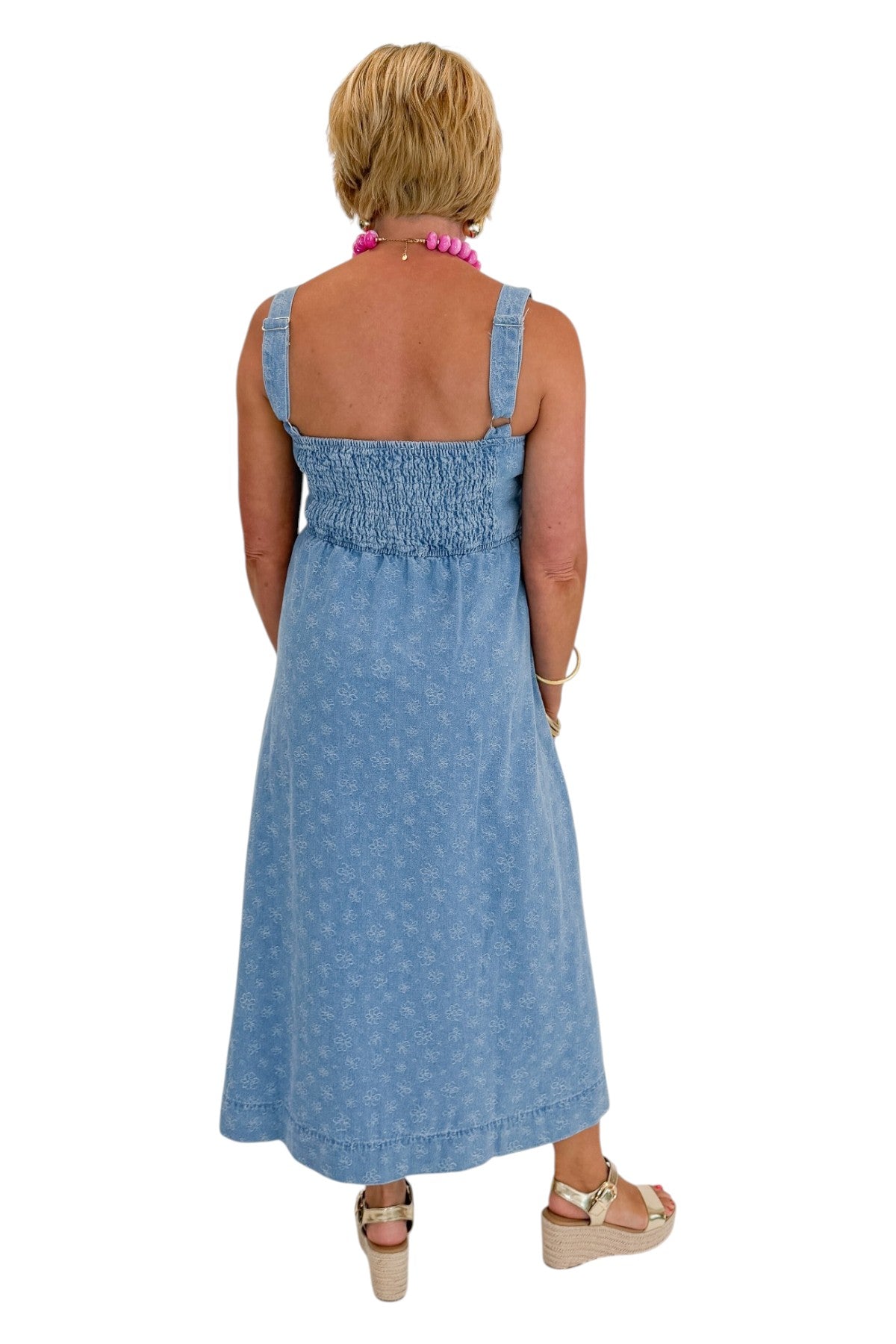 Back view of woman wearing Swagger Boutique’s Denim Floral Textured Midi Dress with wedges against white studio background.