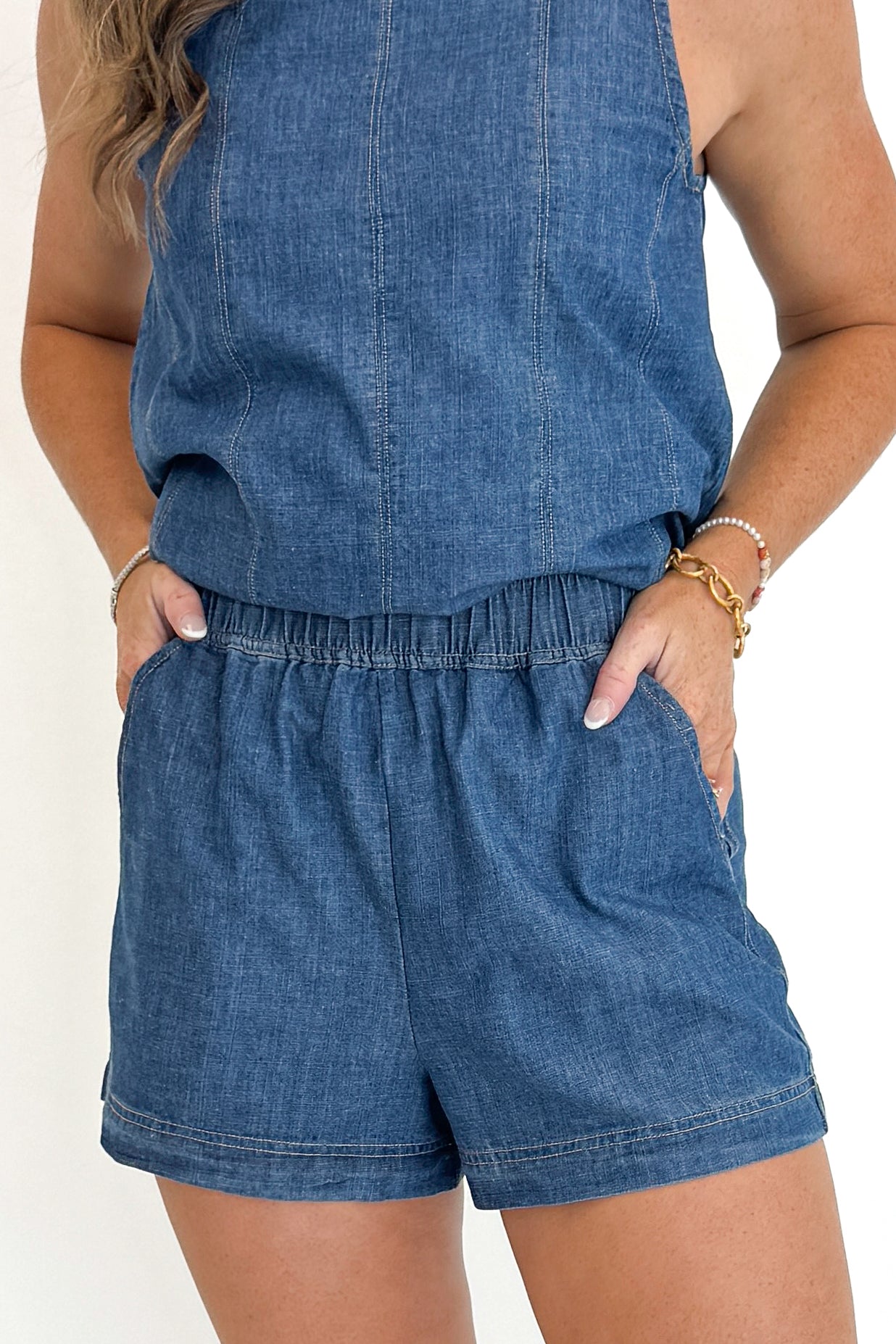 Front detail view of woman wearing Swagger Boutique’s Denim Seam Detail Swing Tank with matching Denim Seam Detail Shorts against white studio background.