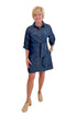 Front view of woman wearing Swagger Boutique’s Denim Tie Detail Button Up Dress by Entro with clogs against white studio background.