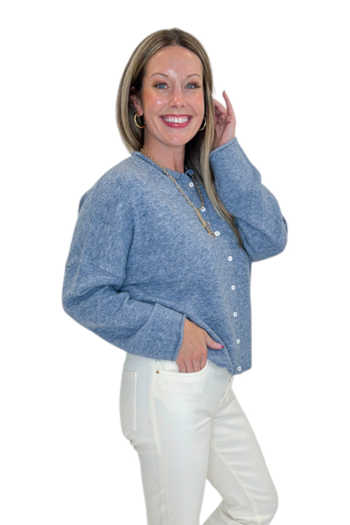 Side view of woman wearing Swagger Boutique’s Dusty Blue Button Up Cardigan with jeans against white studio background.