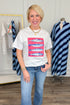 Woman wearing a white t-shirt with a colorful graphic design, standing in a clothing store.