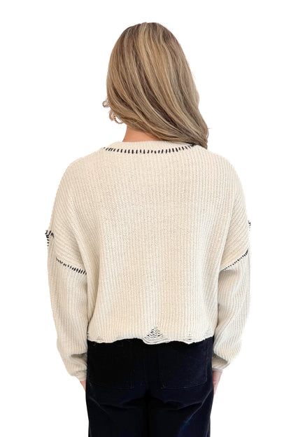 Back view of woman wearing stitch detail oatmeal sweater.