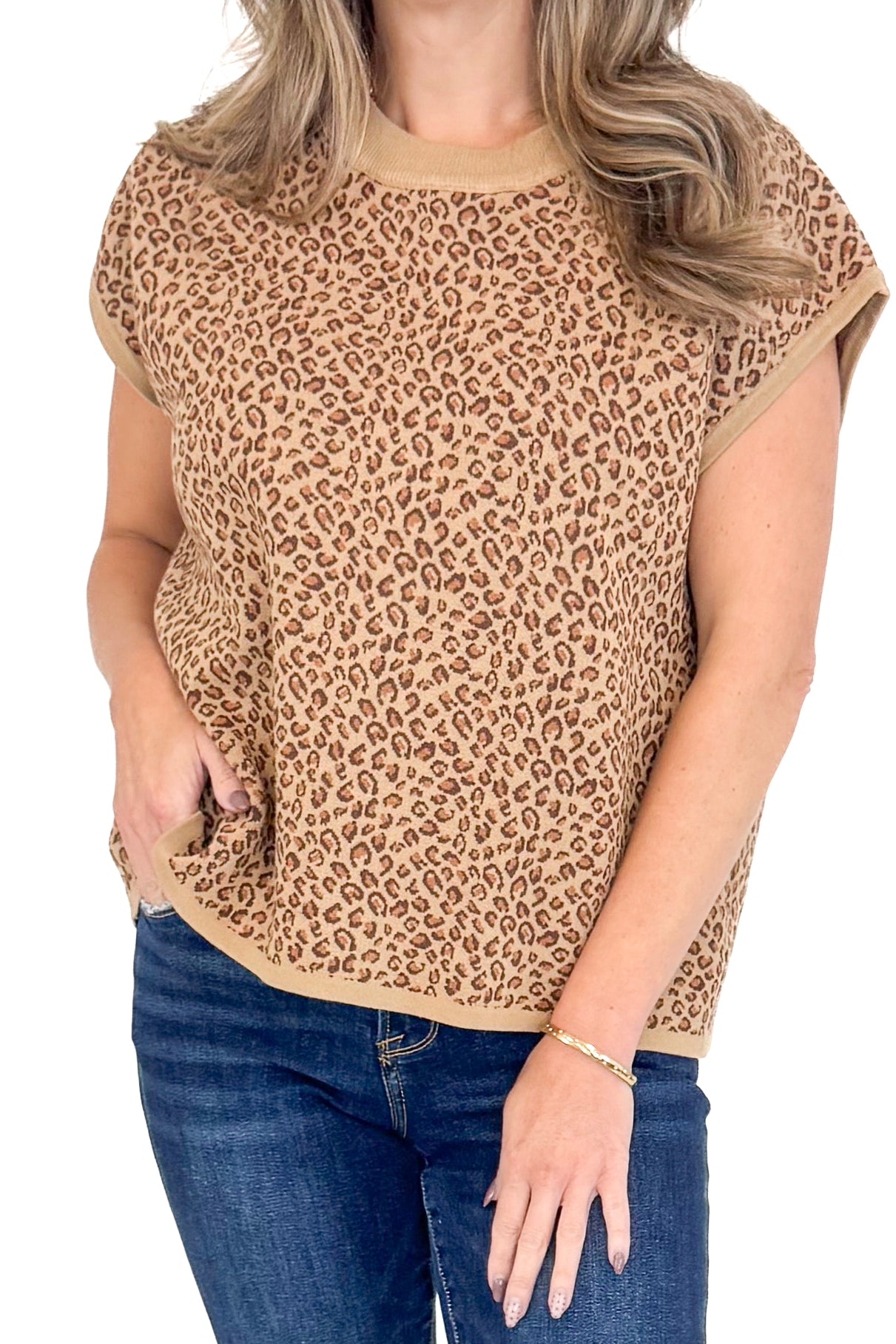 Front detailed view of woman wearing leopard top with jeans against white studio background.