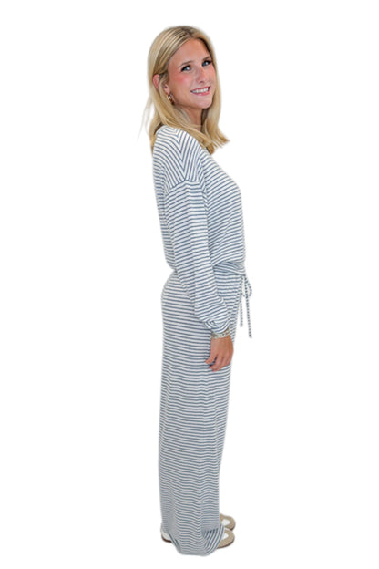 Side view of woman wearing Swagger Boutique’s Eclipse Classic Stripe Pants by Z Supply with Long Sleeve Top against white studio background.