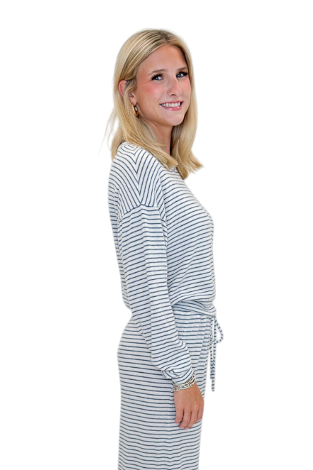 Side view of woman wearing Swagger Boutique’s Eclipse Classic Stripe Pants by Z Supply with Long Sleeve Top against white studio background.