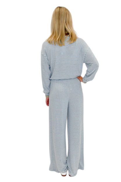 Back view of woman wearing Swagger Boutique’s Eclipse Classic Stripe Pants by Z Supply with Long Sleeve Top against white studio background.